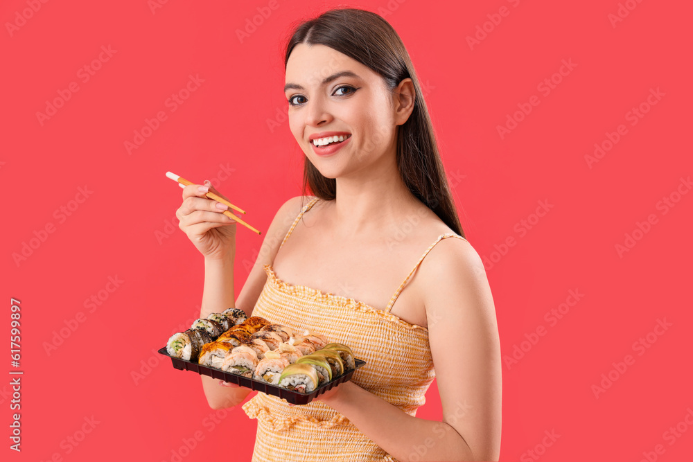 Young woman with sushi on red background