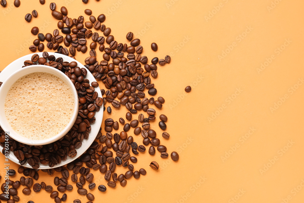 Cup of hot espresso and coffee beans on orange background