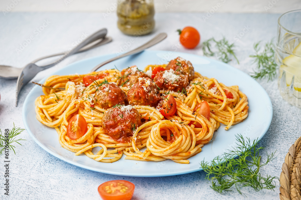 Plate of boiled pasta with tomato sauce and meat balls on white table