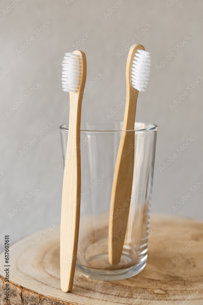 Bamboo tooth brushes and holder on grey background