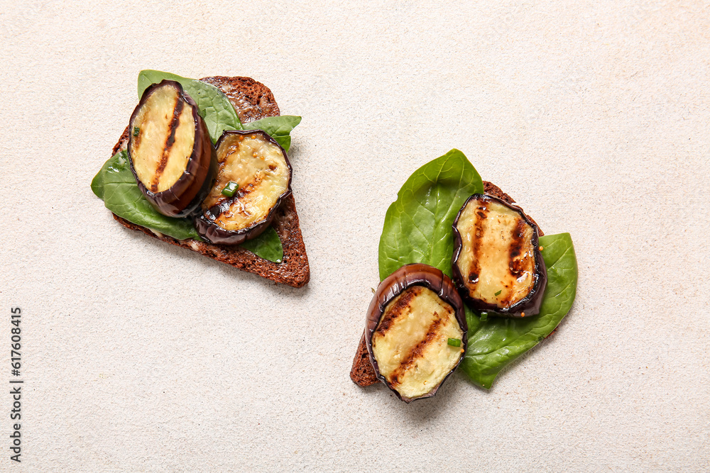 Toasts with delicious grilled eggplants on light background, top view