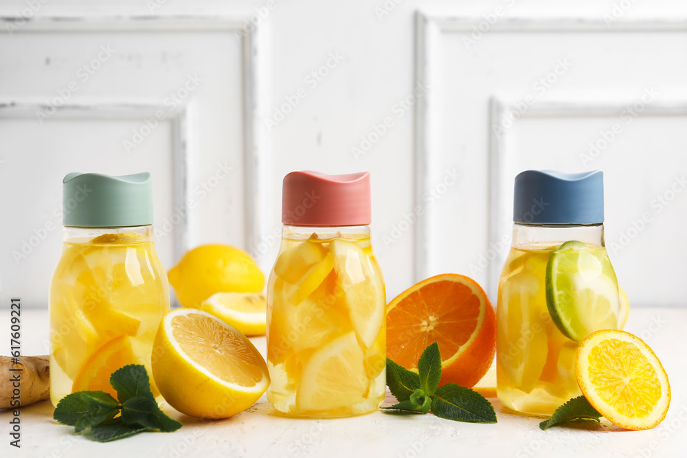 Bottles of infused water with lemon on table