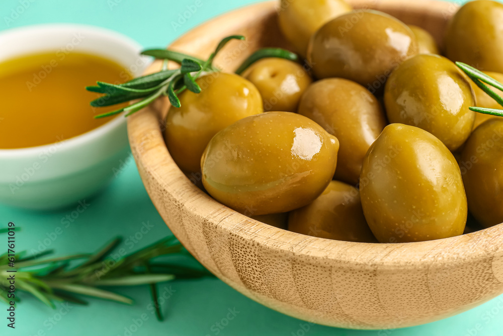 Bowl with ripe olives on turquoise background, closeup