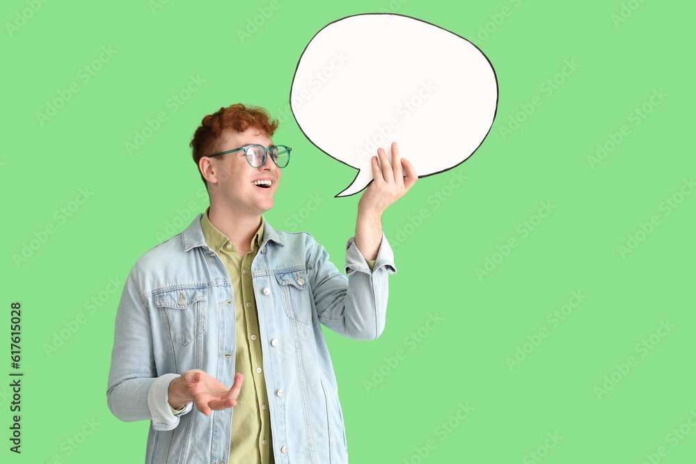 Young redhead man with blank speech bubble on green background