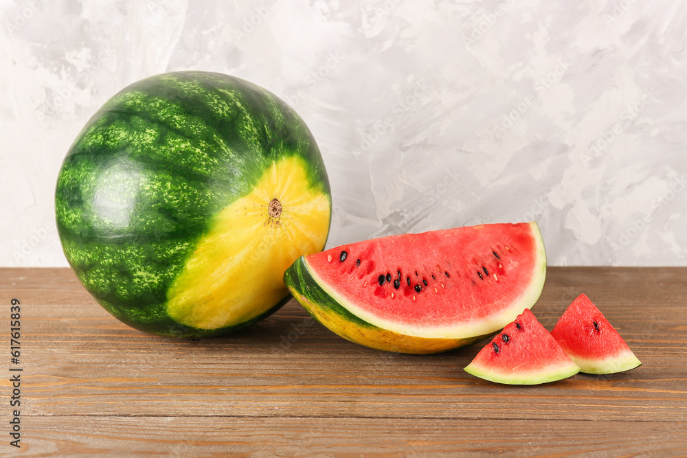 Fresh watermelon and pieces on wooden table