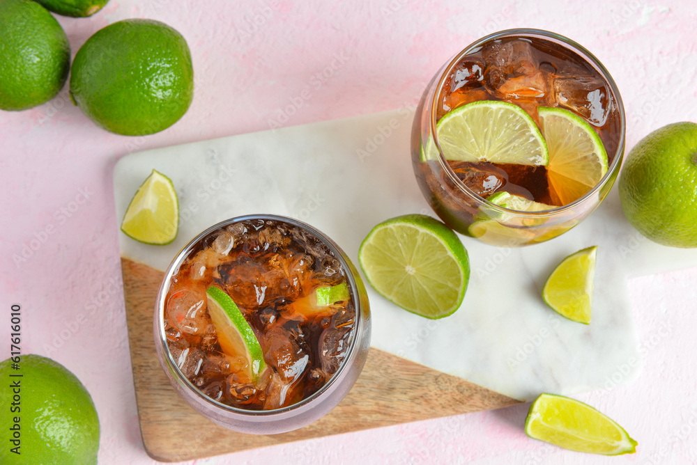 Glasses of cold Cuba Libre cocktail on pink background