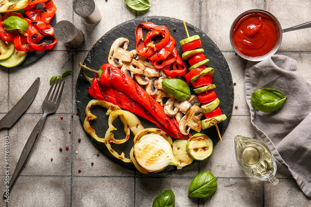 Board with tasty grilled vegetables on grey tile background