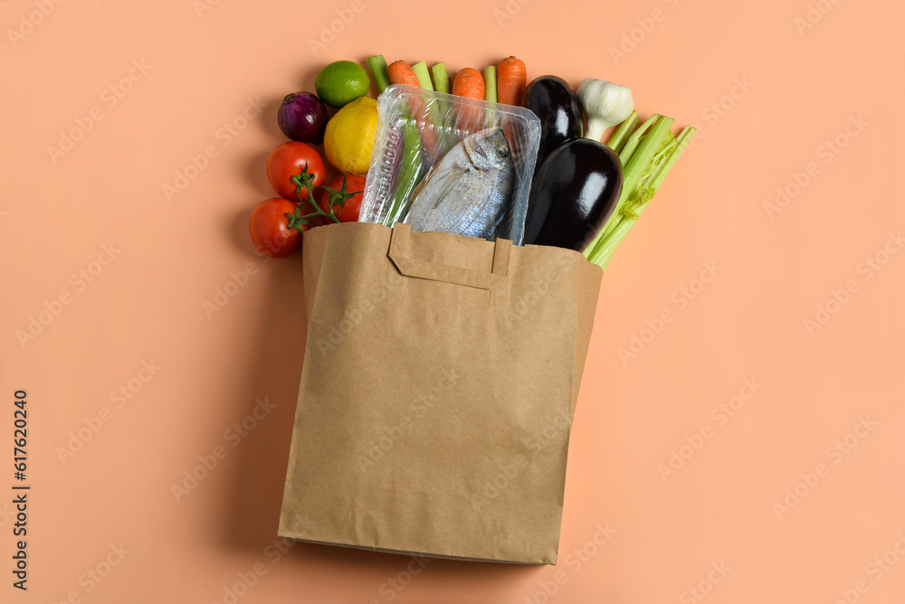 Paper bag with different products on orange background