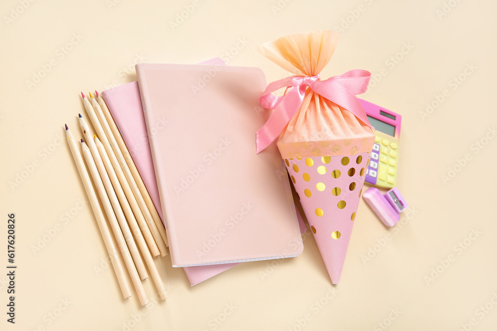 Pink school cone with different stationery on pale orange background