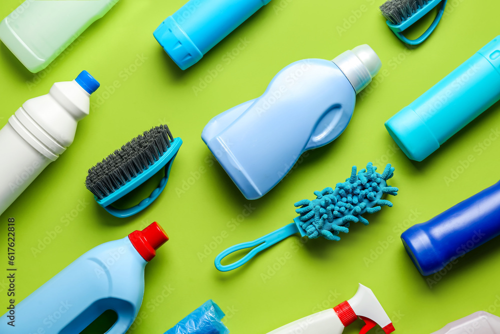 Many different cleaning supplies on green background