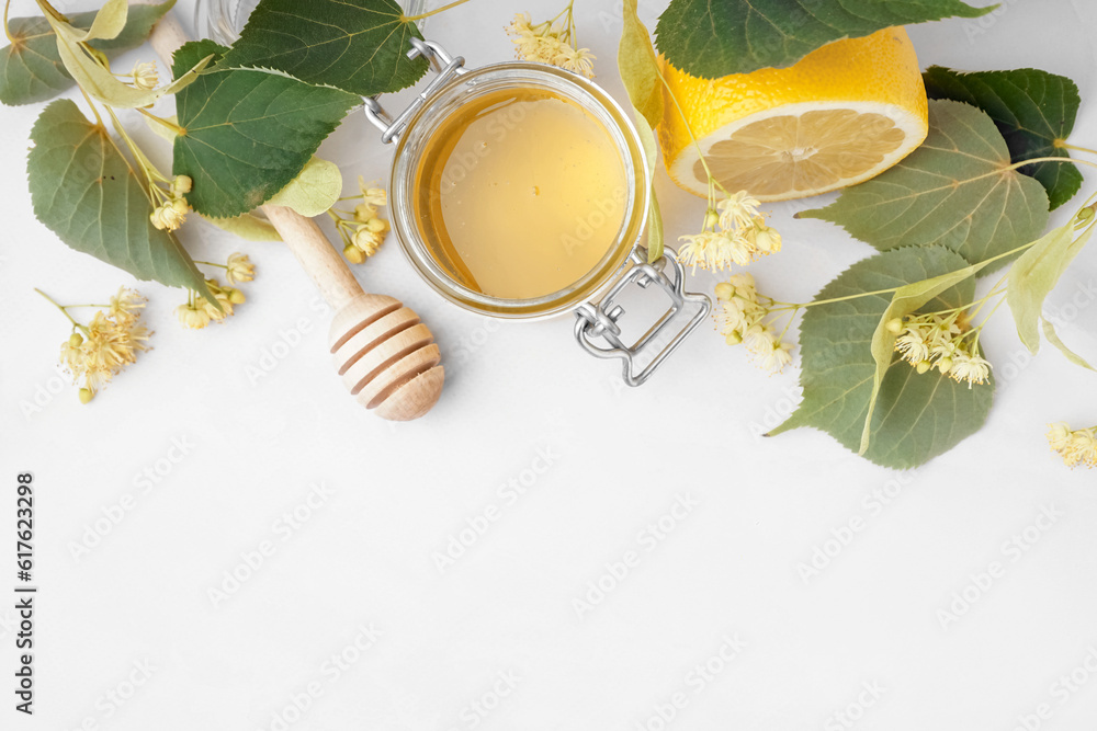 Jar with linden honey and lemon on white background