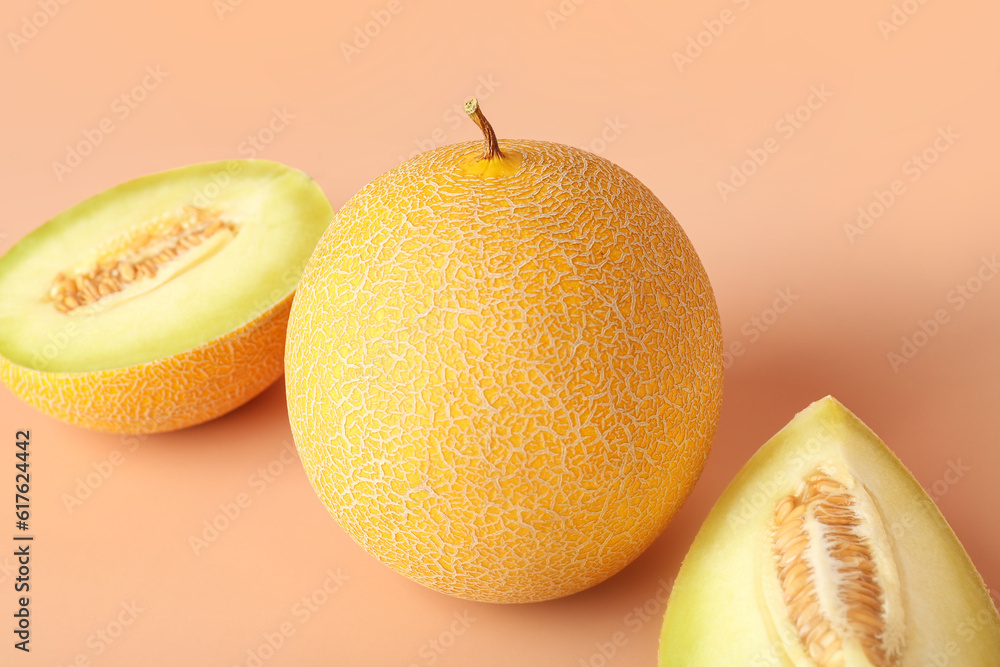 Sweet melon with pieces on orange background