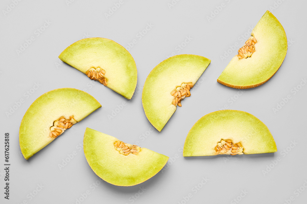 Pieces of sweet melon on grey background