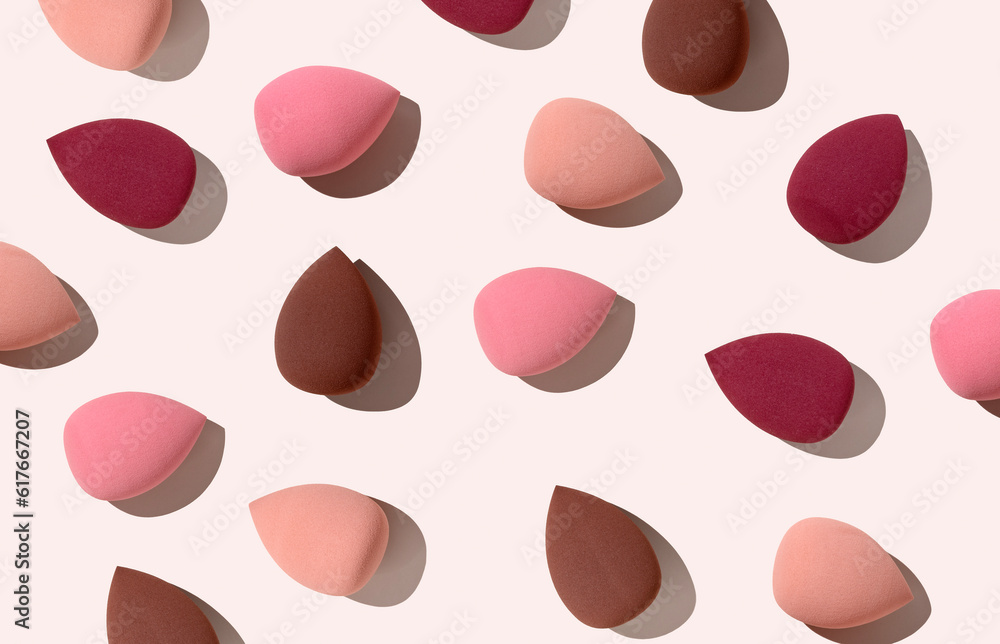 Multiple egg-shaped makeup sponges placed on a beige background.