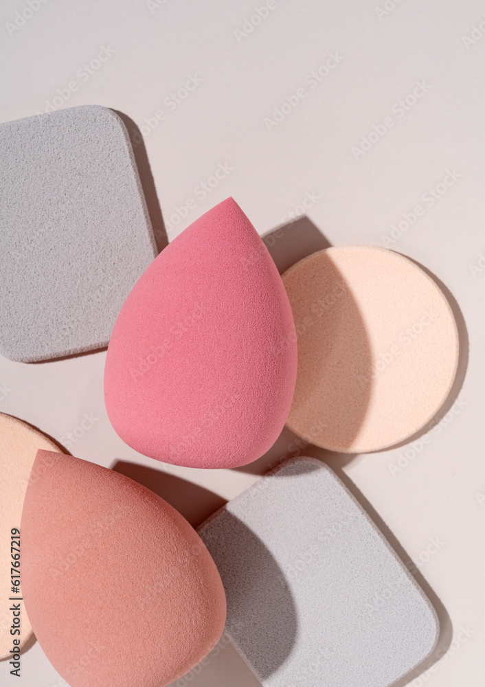 Multiple egg-shaped makeup sponges placed on a beige background.