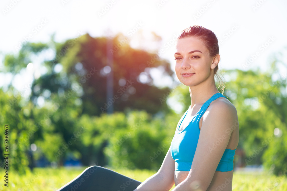 Beautiful smiling girl in sportswear relax in park