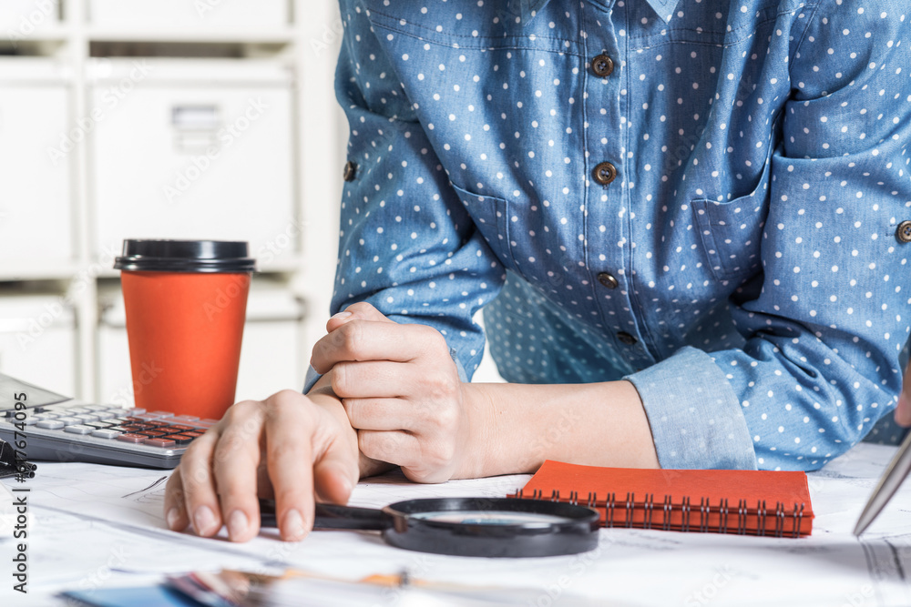 Architect standing near desk with blueprints