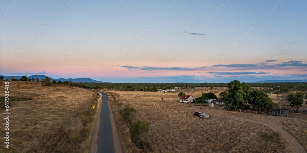 Road across cattle grazing farmland near Rockhampton, Queensland, Australia