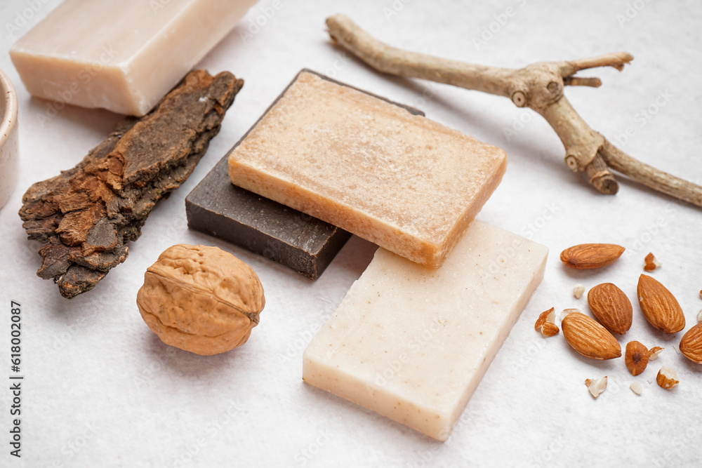 Composition with natural soap bars and nuts on light background, closeup