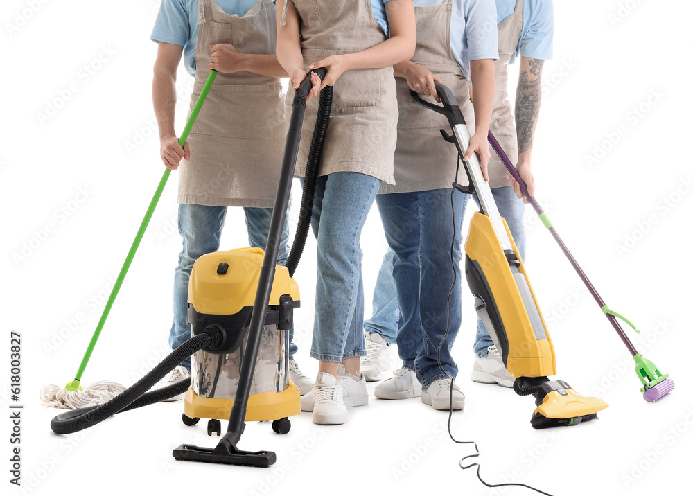 Young janitors with cleaning supplies on white background