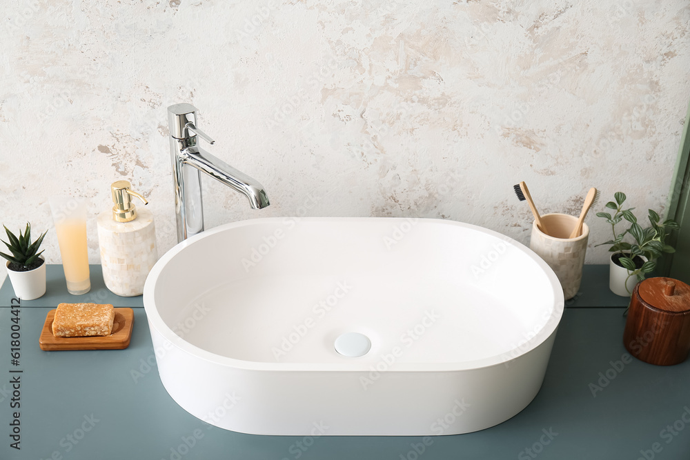 White sink with bath accessories on table in room