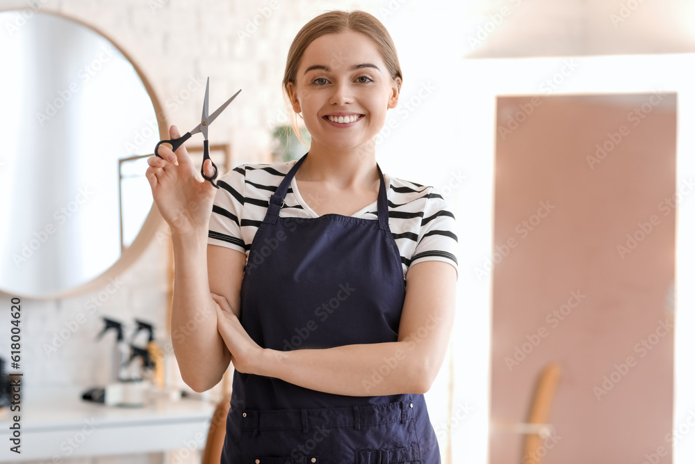 Female hairdresser with scissors in beauty salon