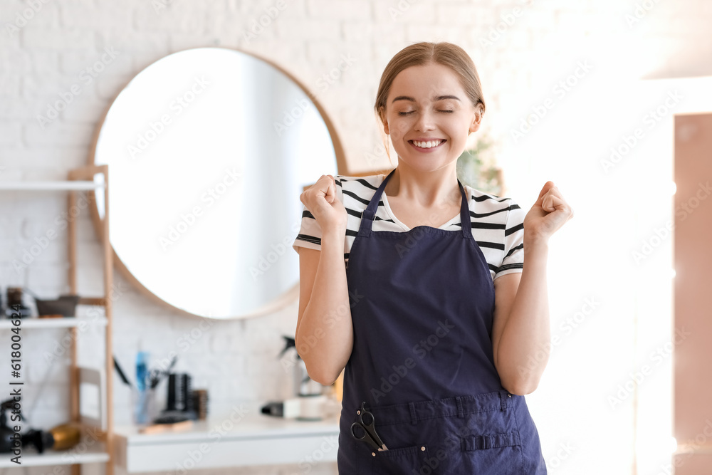 Happy female hairdresser in beauty salon