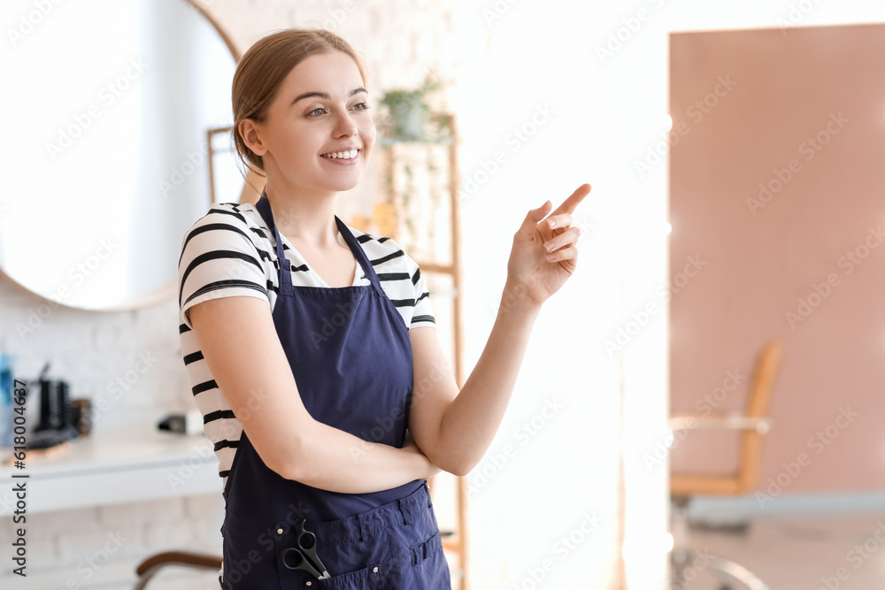 Female hairdresser pointing at something in beauty salon