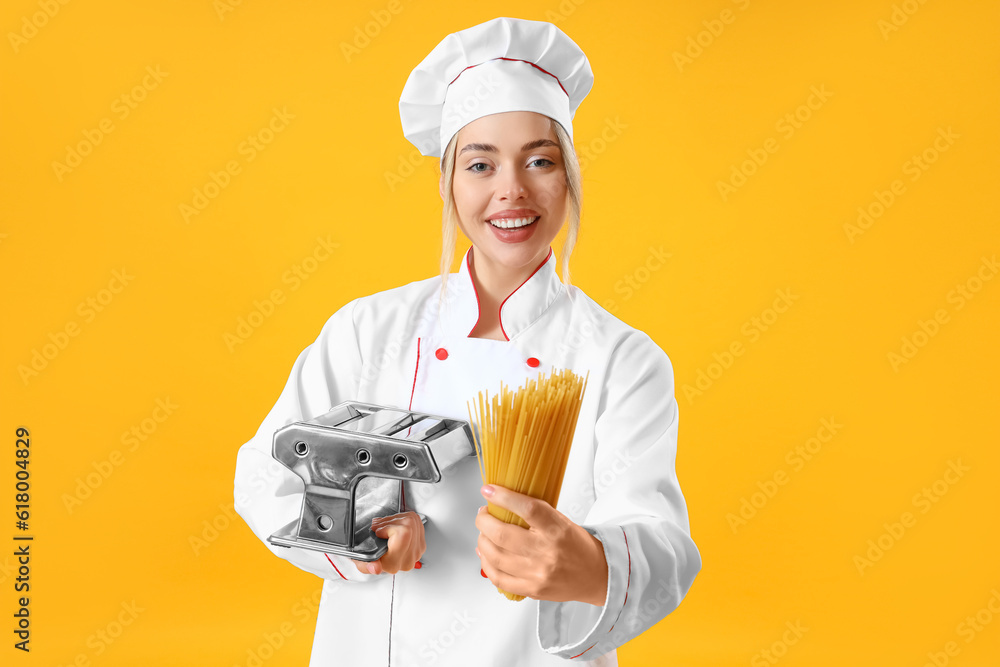 Female chef with pasta maker and raw spaghetti on yellow background