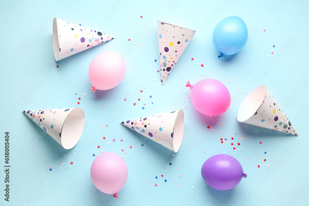 Party hats and balloons on pale blue background