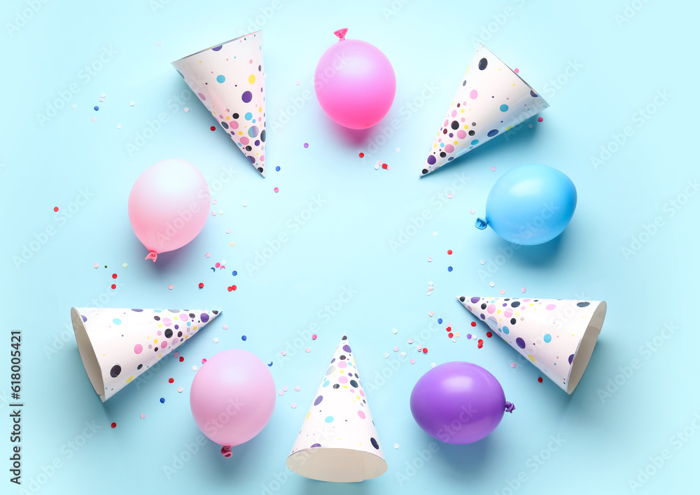 Frame made of party hats and balloons on pale blue background