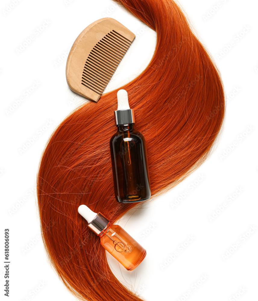 Ginger hair strand, comb and bottles of cosmetic products on white background, closeup