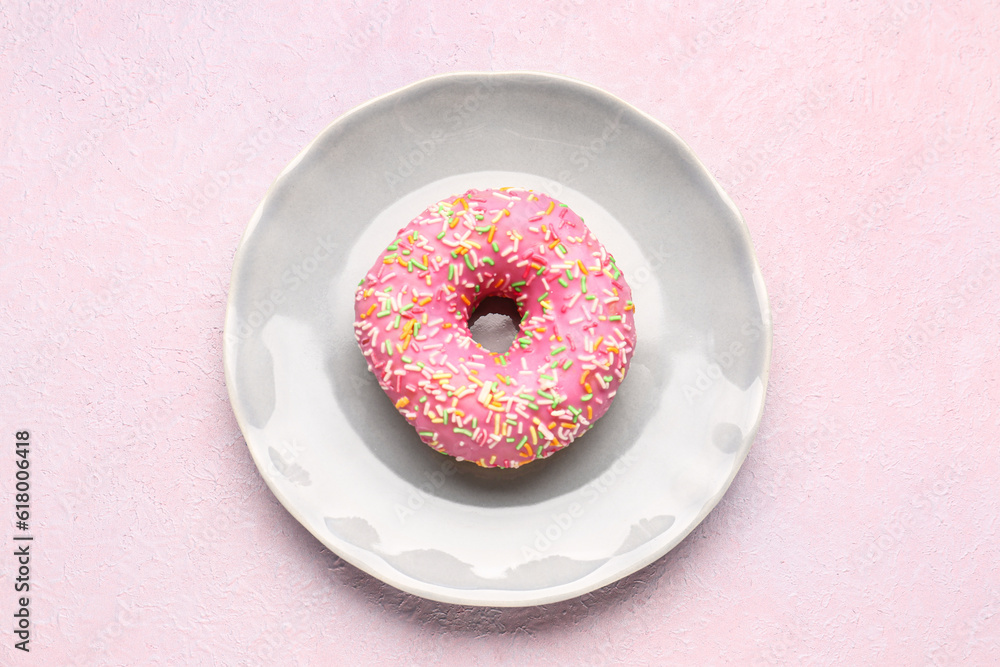 Plate with sweet donut on light background