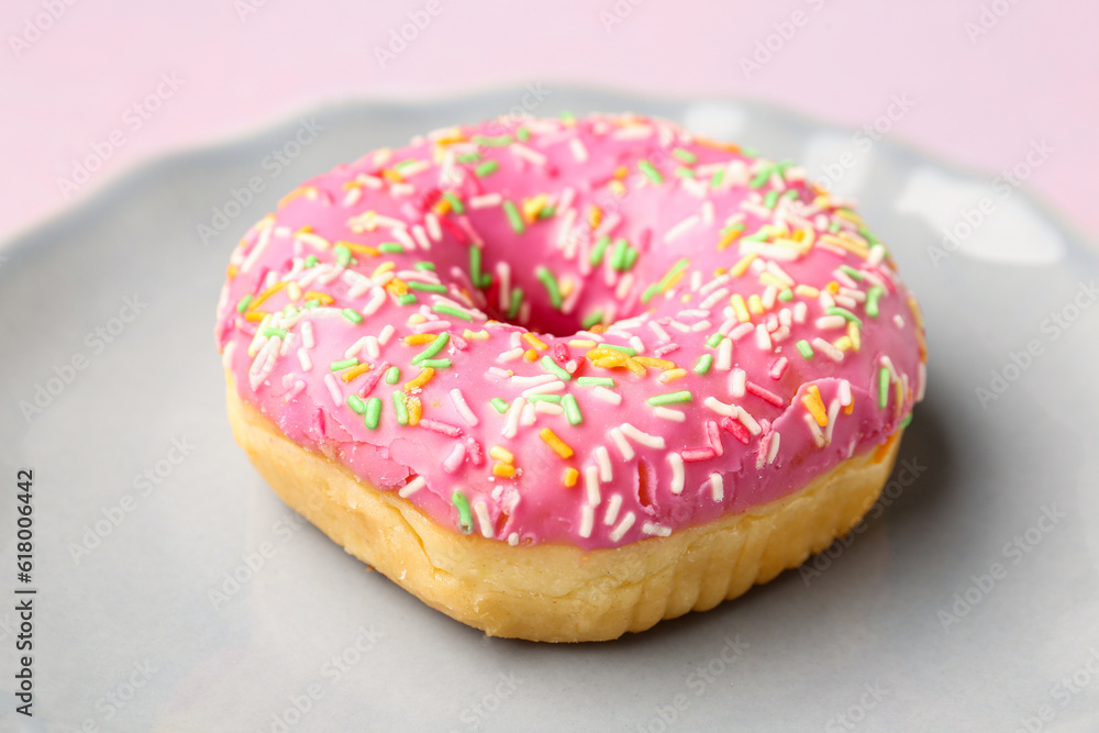 Plate with sweet donut on light background, closeup