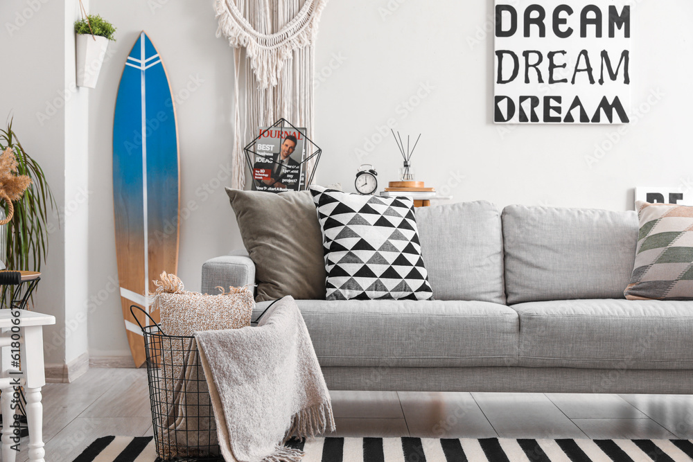 Interior of stylish living room with surfboard and sofa