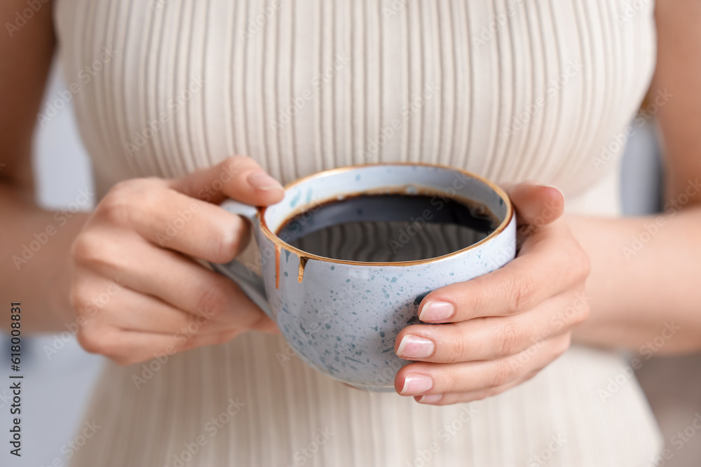 Woman holding cup of delicious coffee, closeup