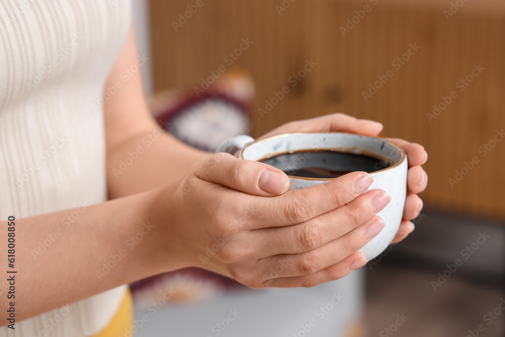 Woman holding cup of delicious coffee, closeup