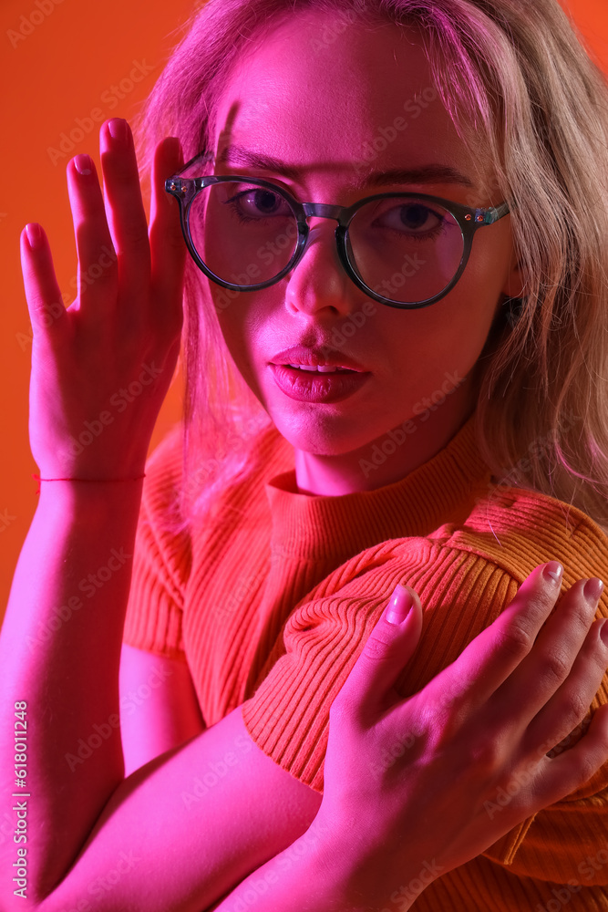 Young woman in stylish eyeglasses on color background, closeup