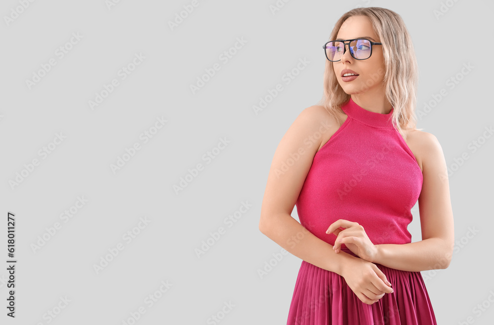 Young woman in stylish eyeglasses on light background