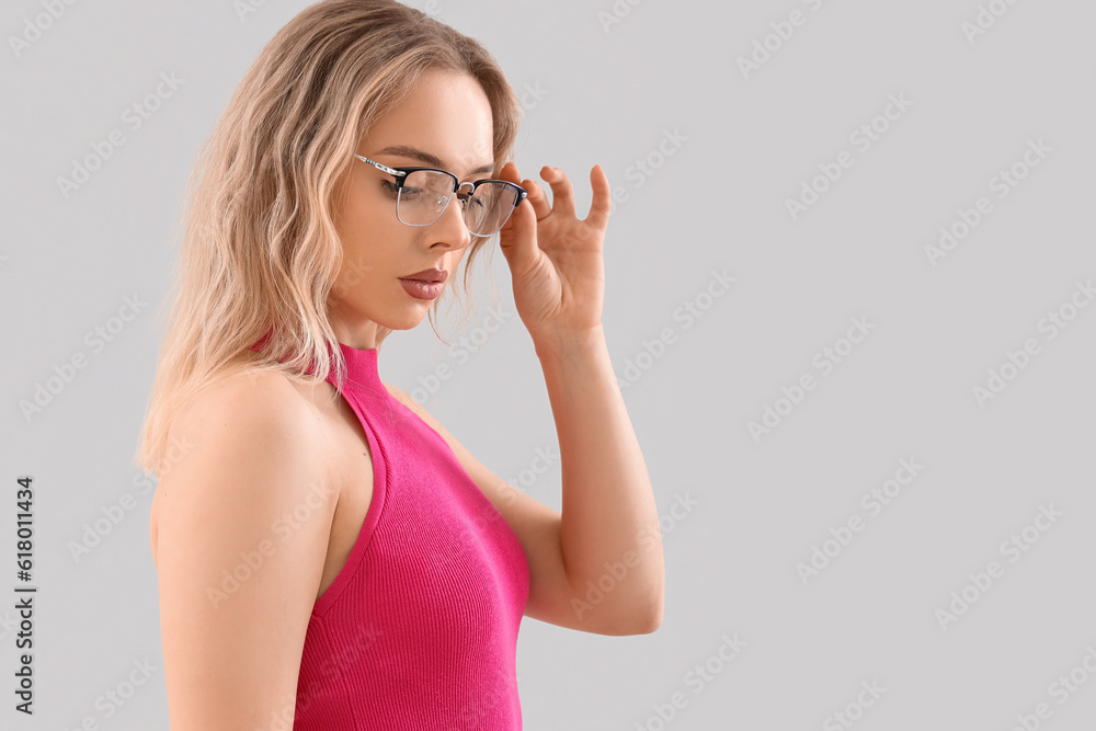 Young woman in stylish eyeglasses on light background, closeup