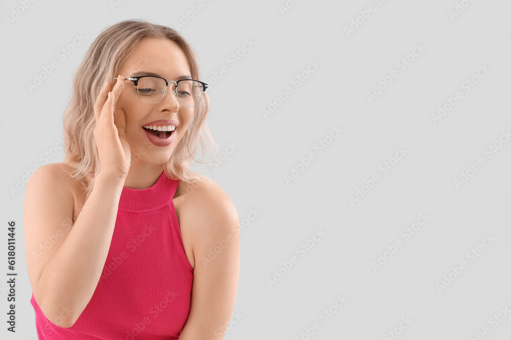 Young woman in stylish eyeglasses on light background