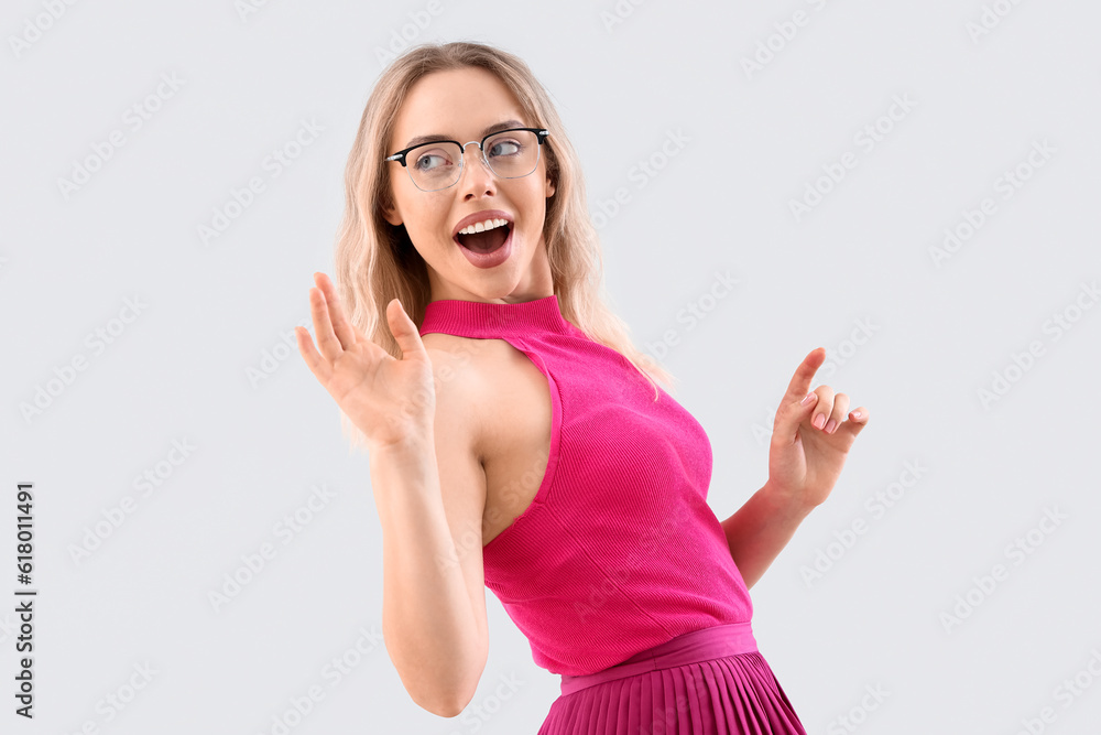 Young woman in stylish eyeglasses on light background