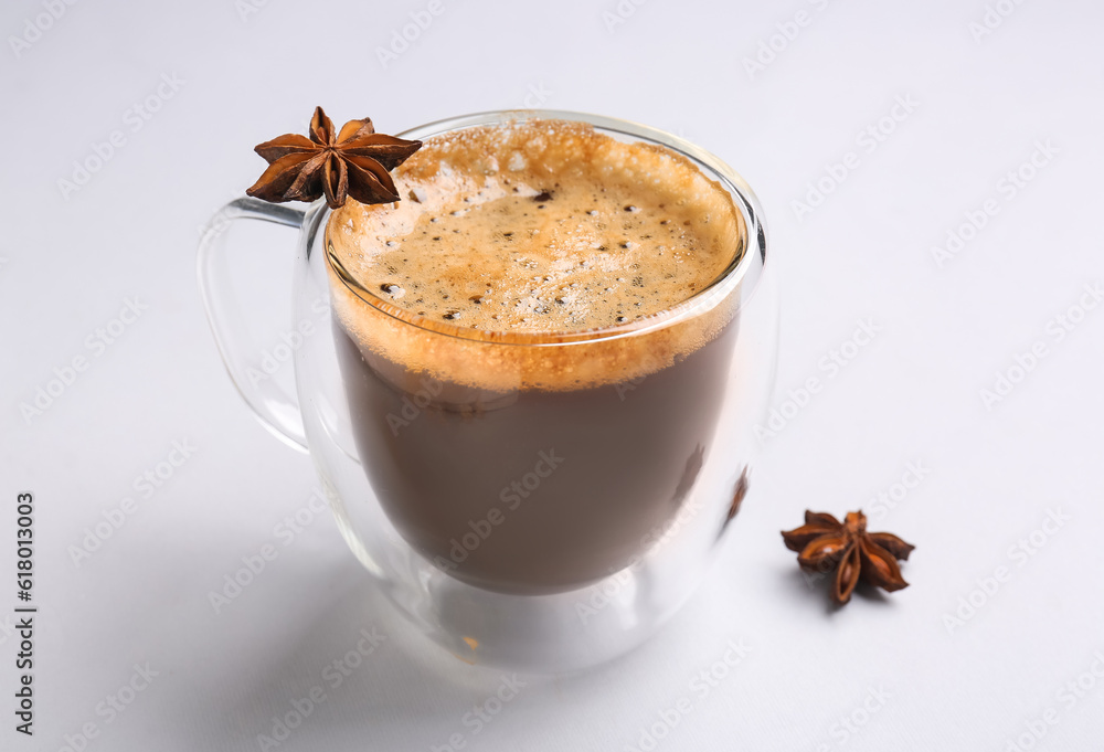 Glass cup of hot espresso with star anise on white background