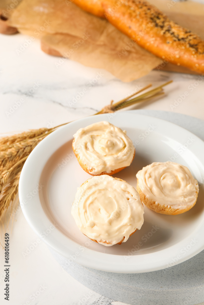 Plate of tasty croutons with cream cheese on white marble background