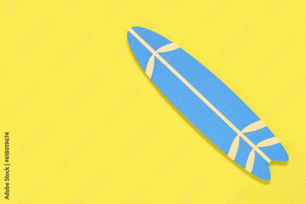 Mini surfboard on yellow background