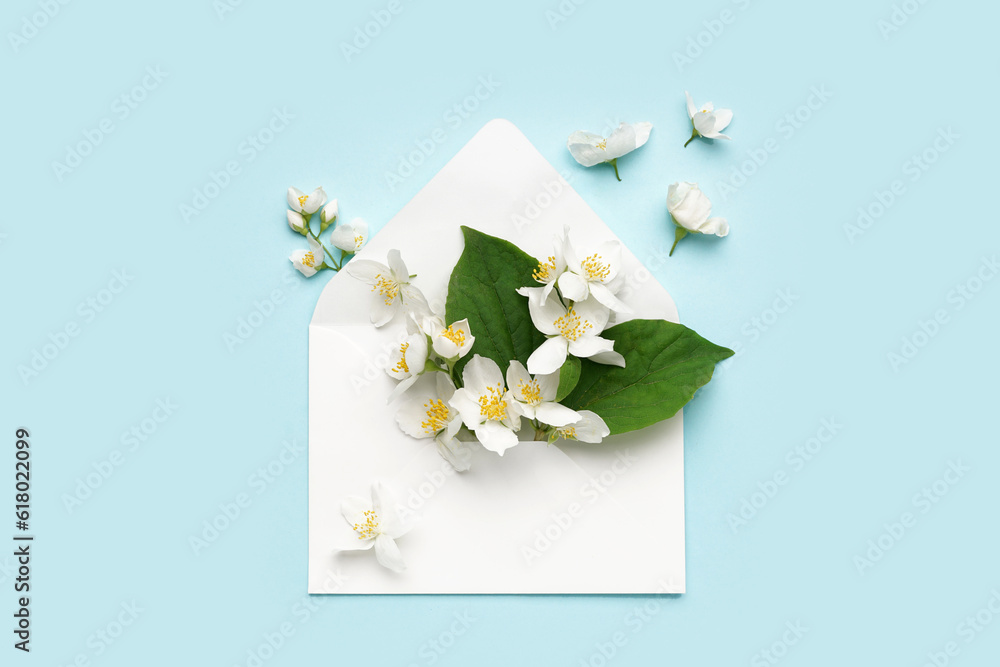 Composition with envelope and beautiful jasmine flowers on color background