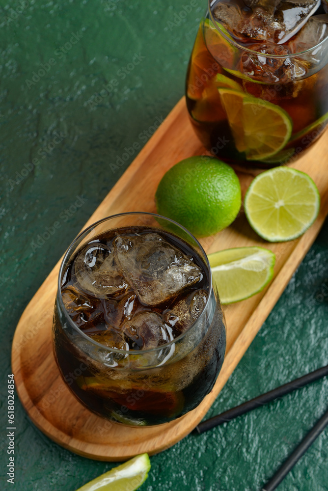 Glasses of cold Cuba Libre cocktail on green background