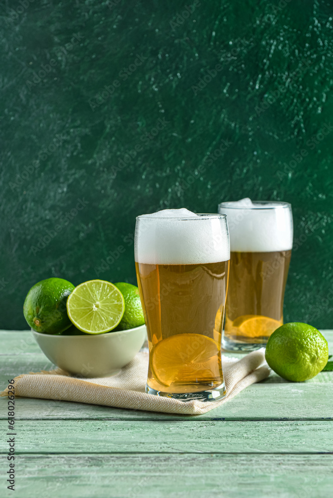 Glasses of cold beer with lime on table