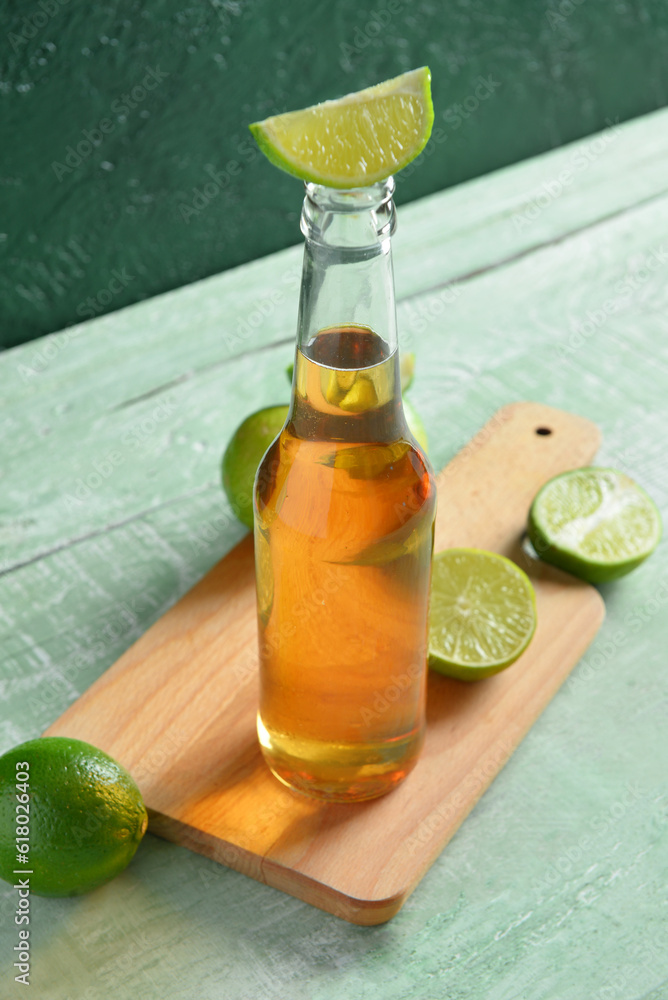 Bottle of cold beer with lime on table