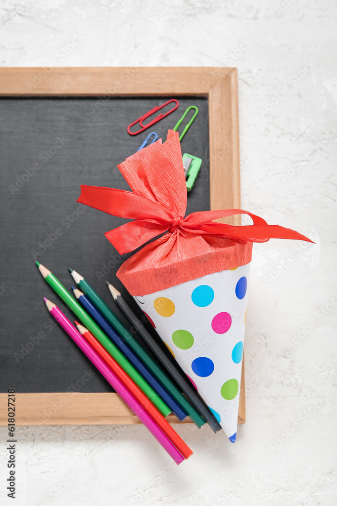 Red school cone with different stationery and blackboard on white background